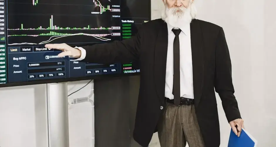 Senior businessman presenting stock market analysis with a chart display in a corporate setting.