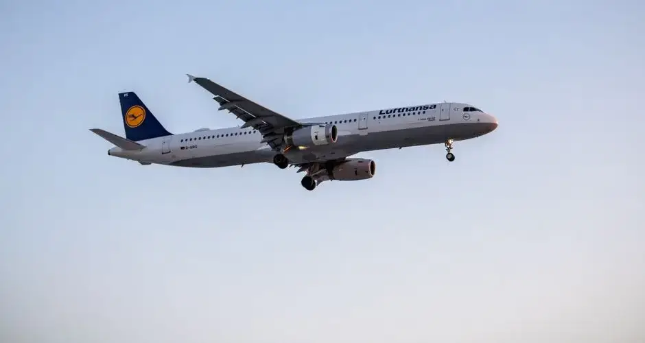 A Lufthansa aircraft flying at sunset against a clear sky, symbolizing modern air travel.