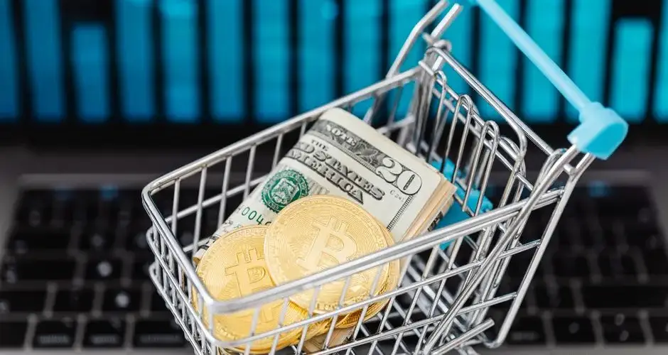 Symbolic image of cryptocurrency and cash in a shopping cart on a laptop, representing digital finance and trading.