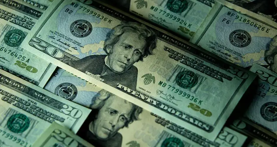 Close-up of multiple US twenty dollar bills depicting wealth and finance.