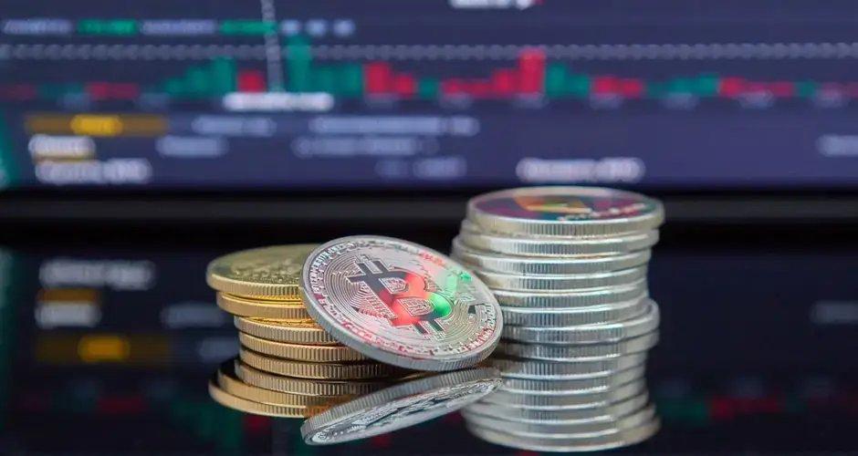 Close-up of cryptocurrency coins with a market graph background.