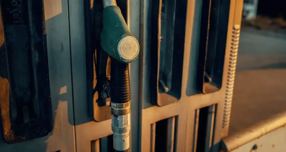 A detailed view of a gas pump nozzle during sunset in Österreich, highlighting industrial design.