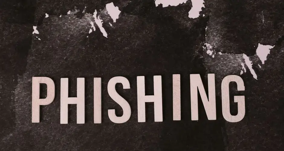 Abstract representation of phishing with the text on a textured dark surface.