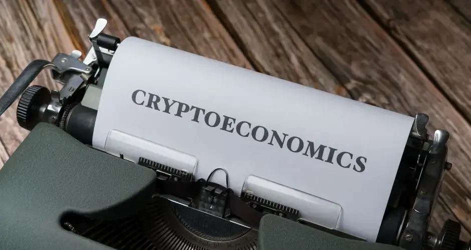 Cryptoeconomics typed on paper using vintage typewriter on wooden background.