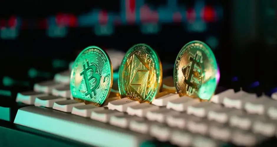 Close-up of Bitcoin and Ethereum coins placed on a keyboard, with market charts in the background.
