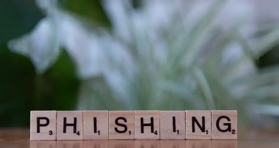 Wooden tiles spelling 'phishing' highlight cybersecurity themes.