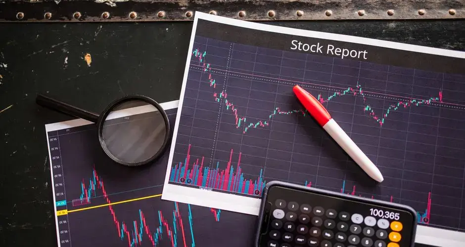 Stock report with charts, calculator, and magnifying glass for financial analysis.