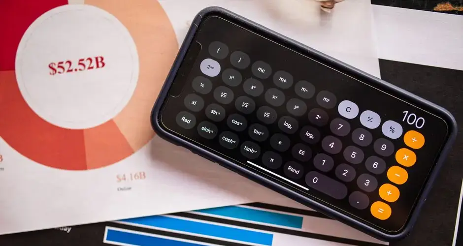 A smartphone displaying a calculator app on financial charts, showcasing revenue analysis.