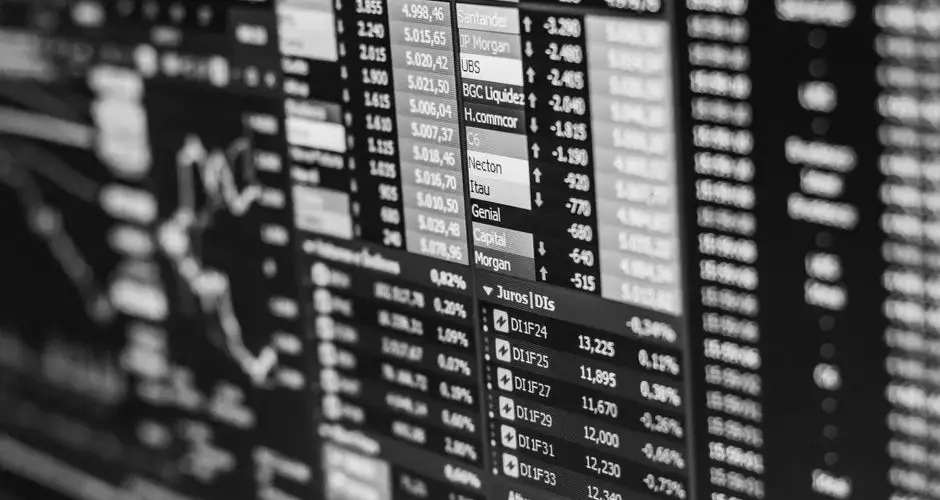 Monochrome image of stock market data on a screen, depicting financial information and trends.