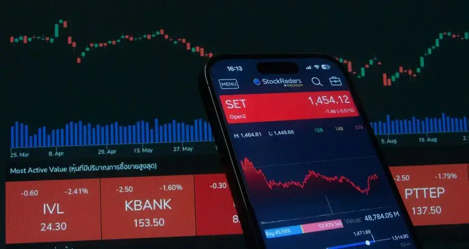 Mobile app showing stock market data with charts on screen.