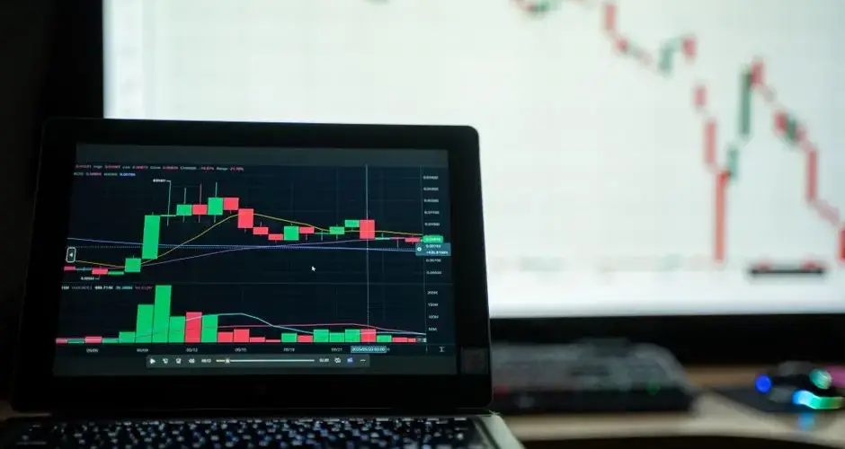 Close-up of a laptop showing cryptocurrency market charts in a trading environment.