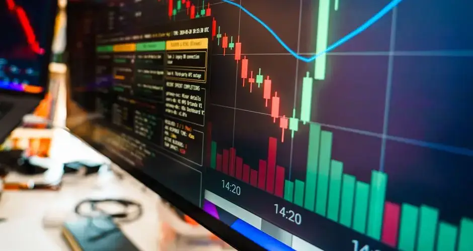 Close-up of a financial monitor displaying real-time cryptocurrency data and charts in a modern office.