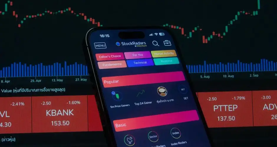 Close-up of a smartphone displaying a stock trading app against a backdrop of market charts.