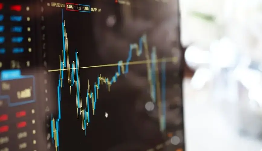 Detailed view of financial trading graphs on a monitor, illustrating stock market trends.
