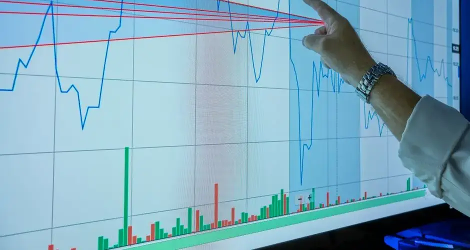 Closeup of hand analyzing financial graph on a digital screen for market trends and investment insights.