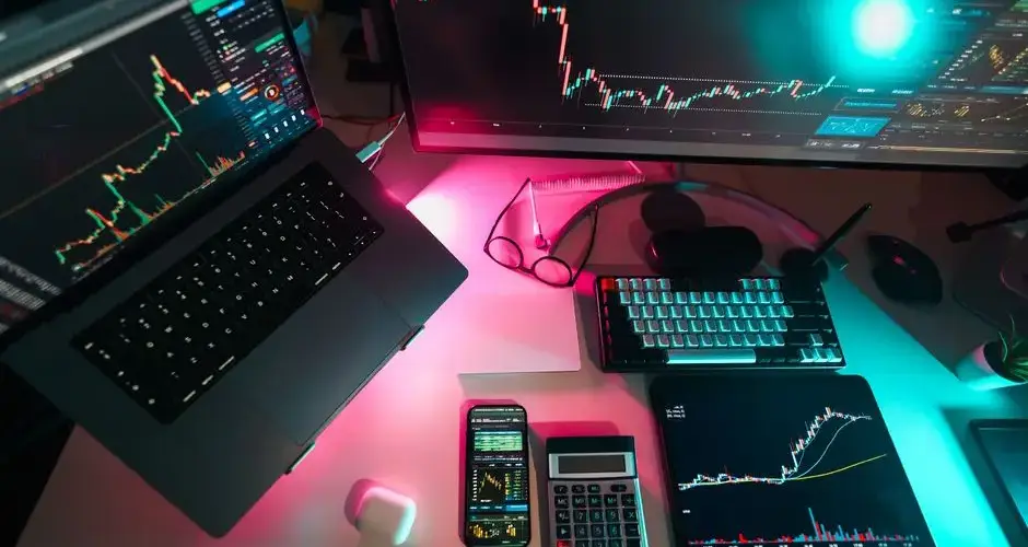High-tech trading setup featuring digital charts on multiple devices, ideal for finance professionals.
