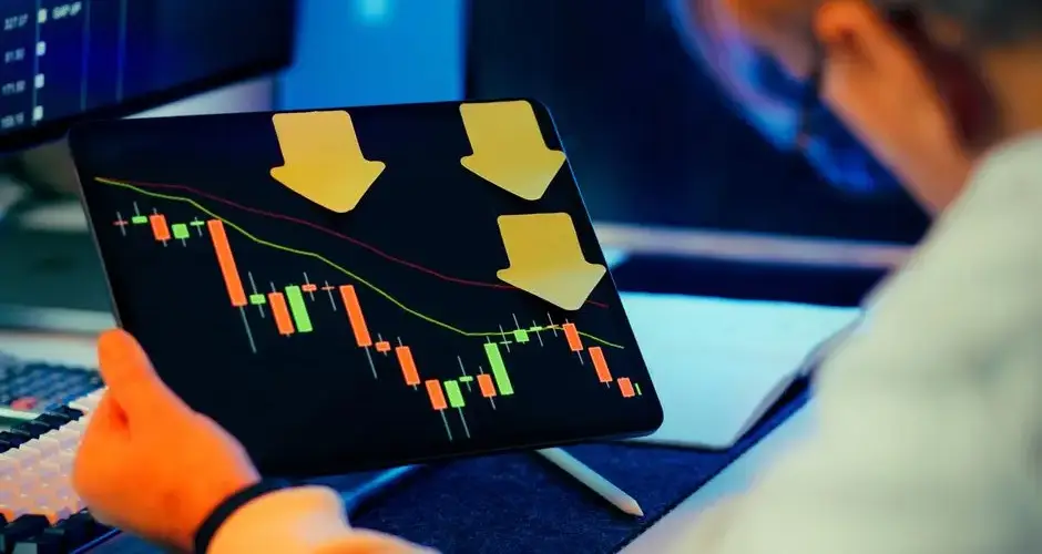 A businessman analyzing a bearish stock market trend on a tablet, indicating financial instability and potential crisis.