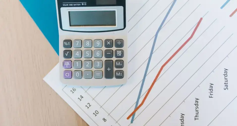 Top view of calculator and graph paper on office desk, perfect for business themed visuals.