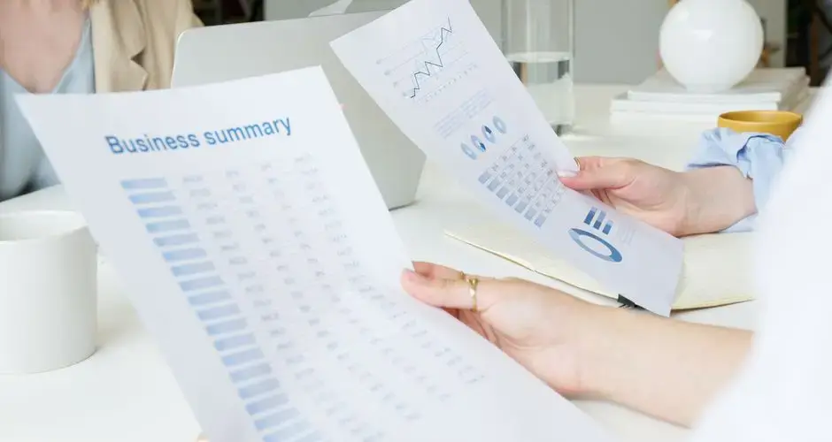 Two business professionals analyzing reports in a modern office setting.