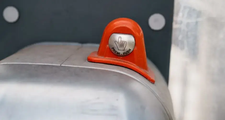 A detailed image of an orange industrial push button labeled 'Premi-Push.'