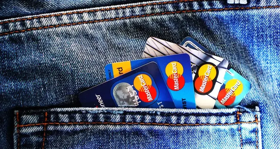 Close-up of a denim pocket with multiple credit cards, illustrating finance and fashion.