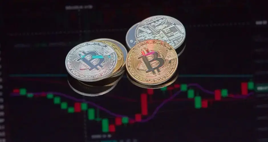 Close-up view of Bitcoin coins on a stock market chart background representing cryptocurrency trading.
