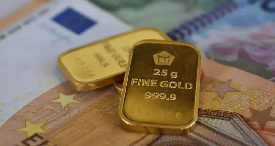 Detailed view of gold bullion bars placed on European currency euro banknotes, symbolizing wealth and investment.