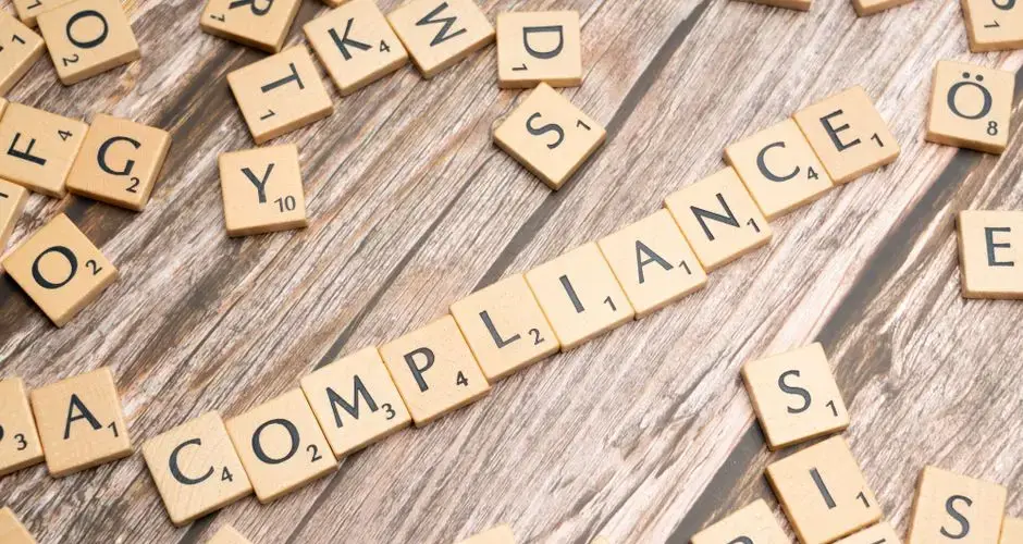 Wooden letter tiles forming the word 'COMPLIANCE' on a rustic wooden background.