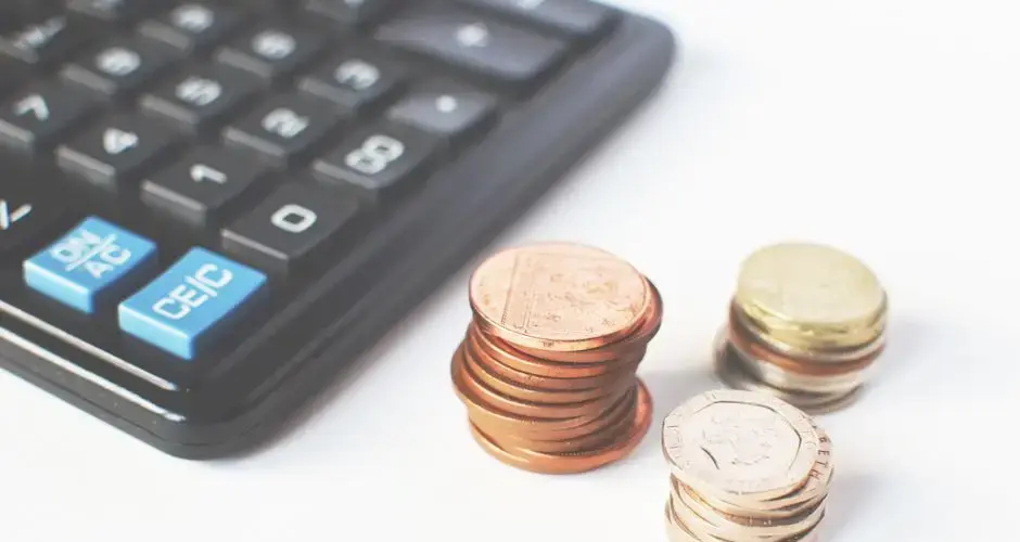 Close-up of stacked coins and a calculator symbolizing financial strategy and budgeting.