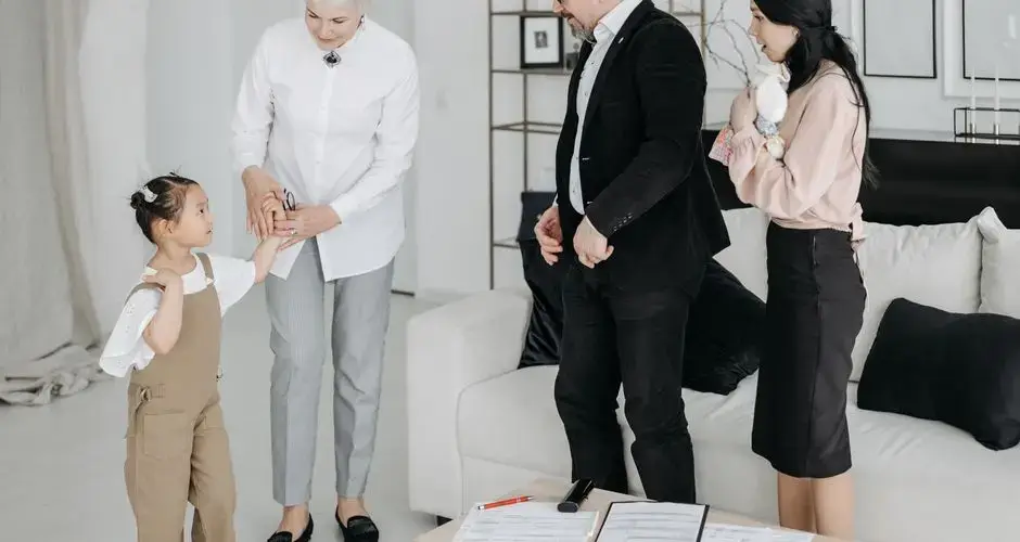 A joyful meeting of adoptive parents and child with a social worker in a modern interior.